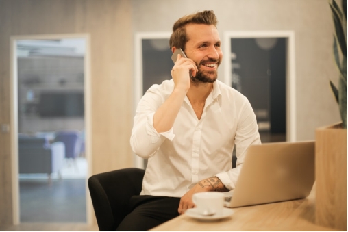 A person using a laptop and his phone