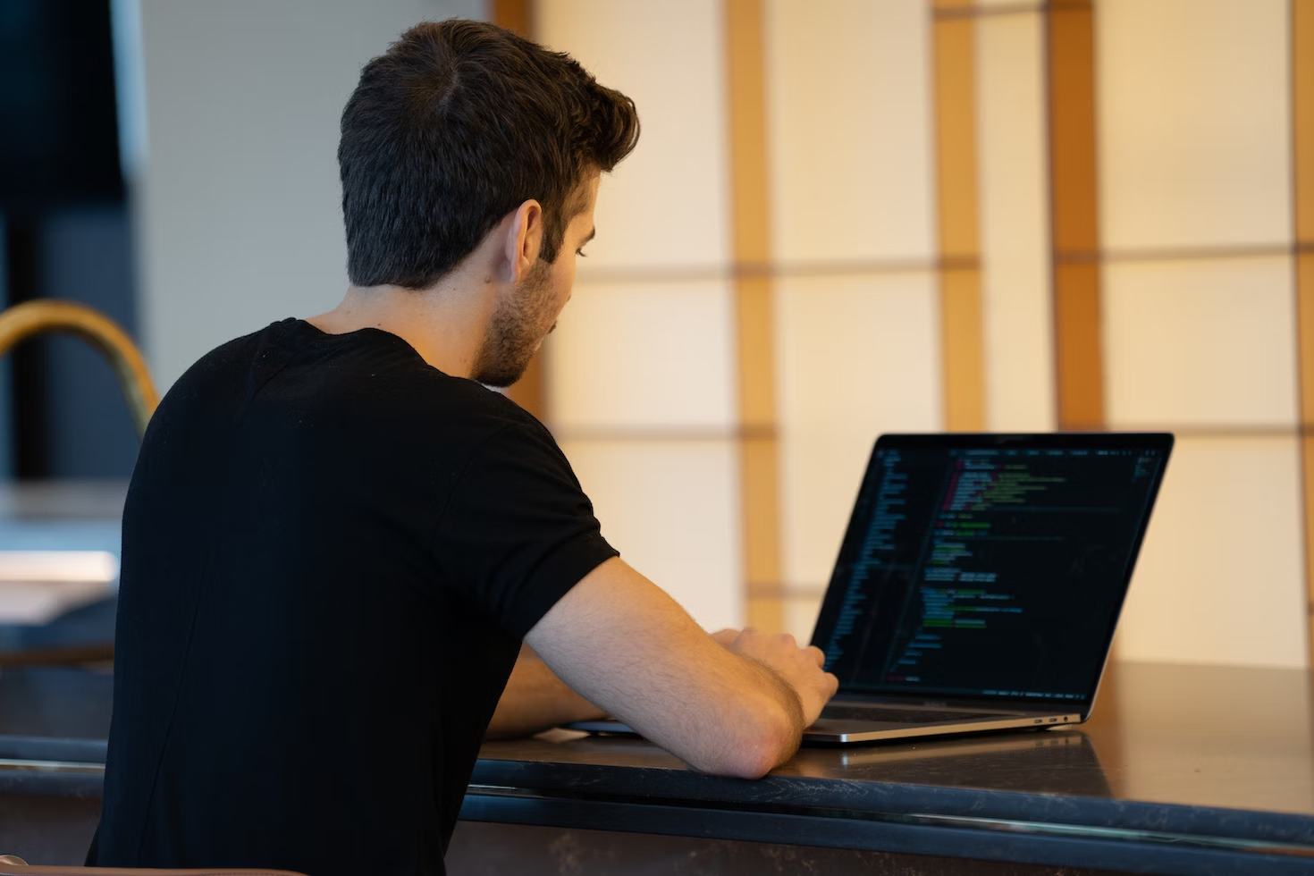 An individual coding on their laptop