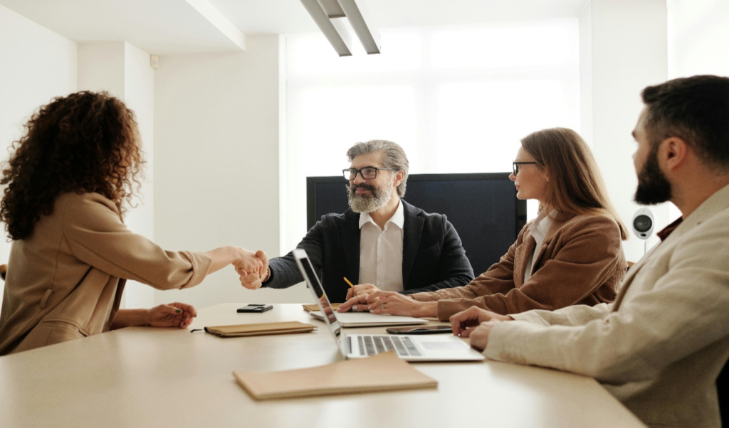 A candidate shaking hands with one of the interviewers at an interview.