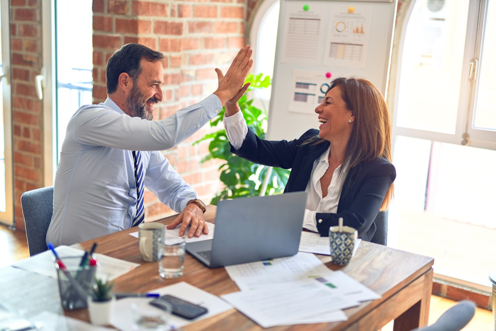 A photo of two people high-fiving each other