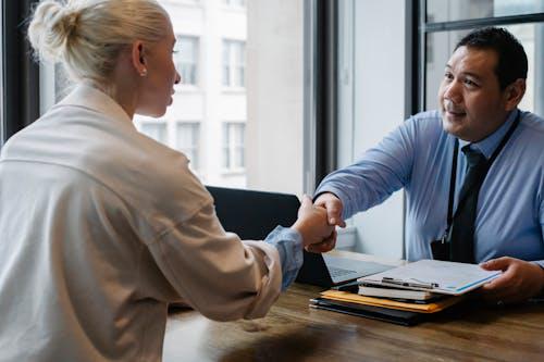 A recruitment specialist shaking the hand of an applicant in the office