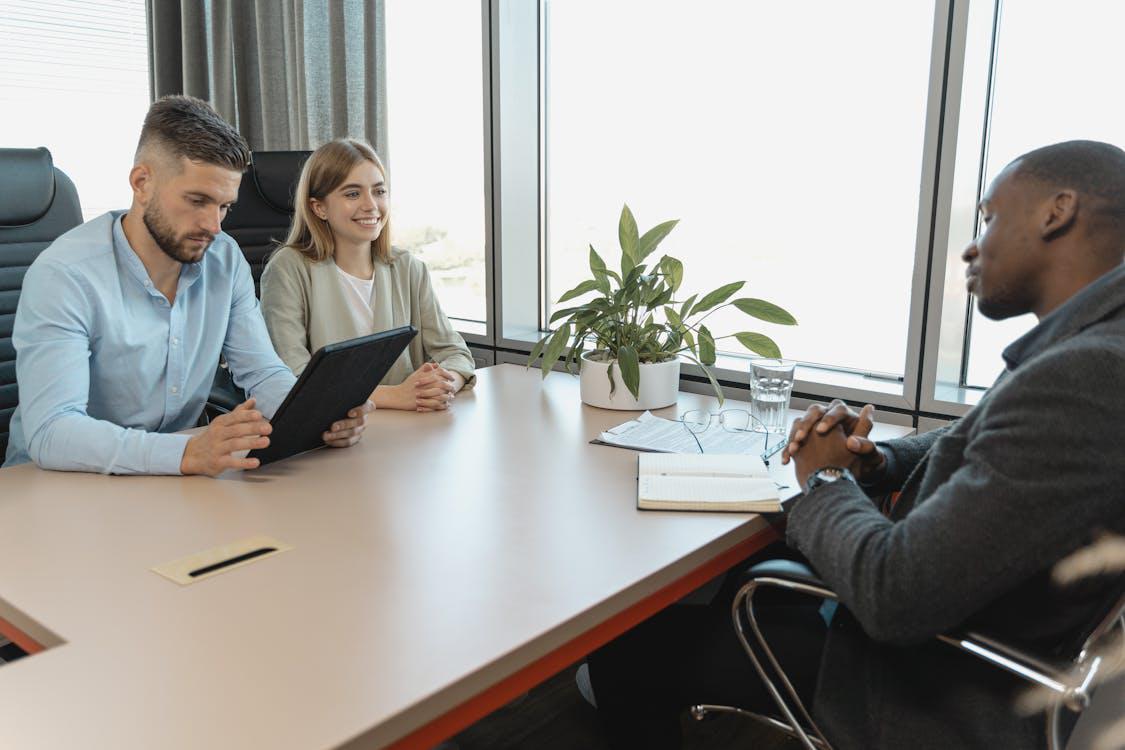 A white male and female interviewers interviewing a black male