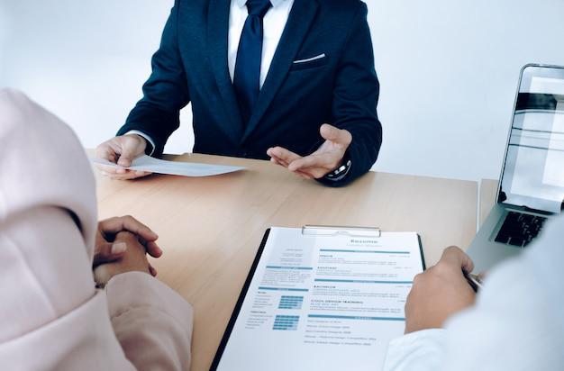 An image of an interview being conducted with a candidate’s resume on the desk