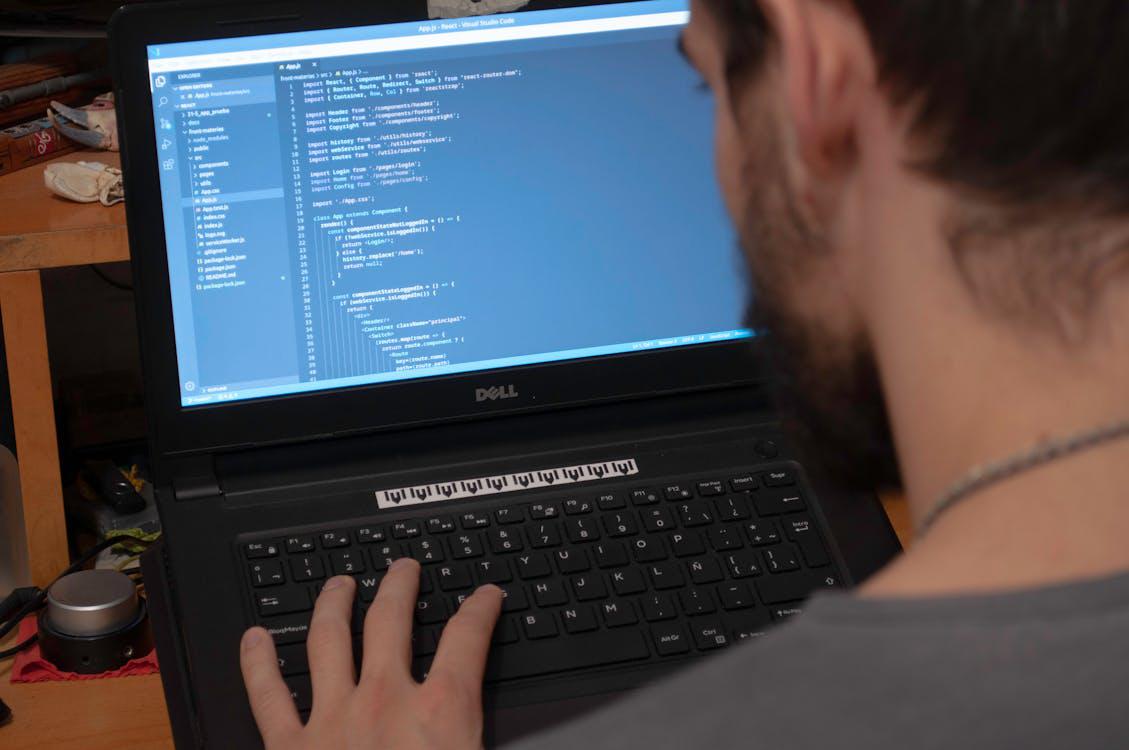 An image of a person doing coding on a laptop