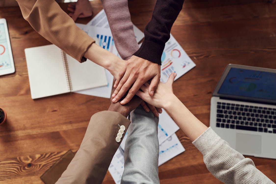 An image of employees with their hands on top of each other