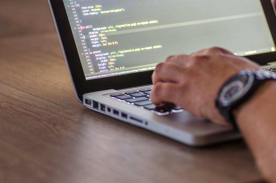  A closeup image of a person coding on a laptop 