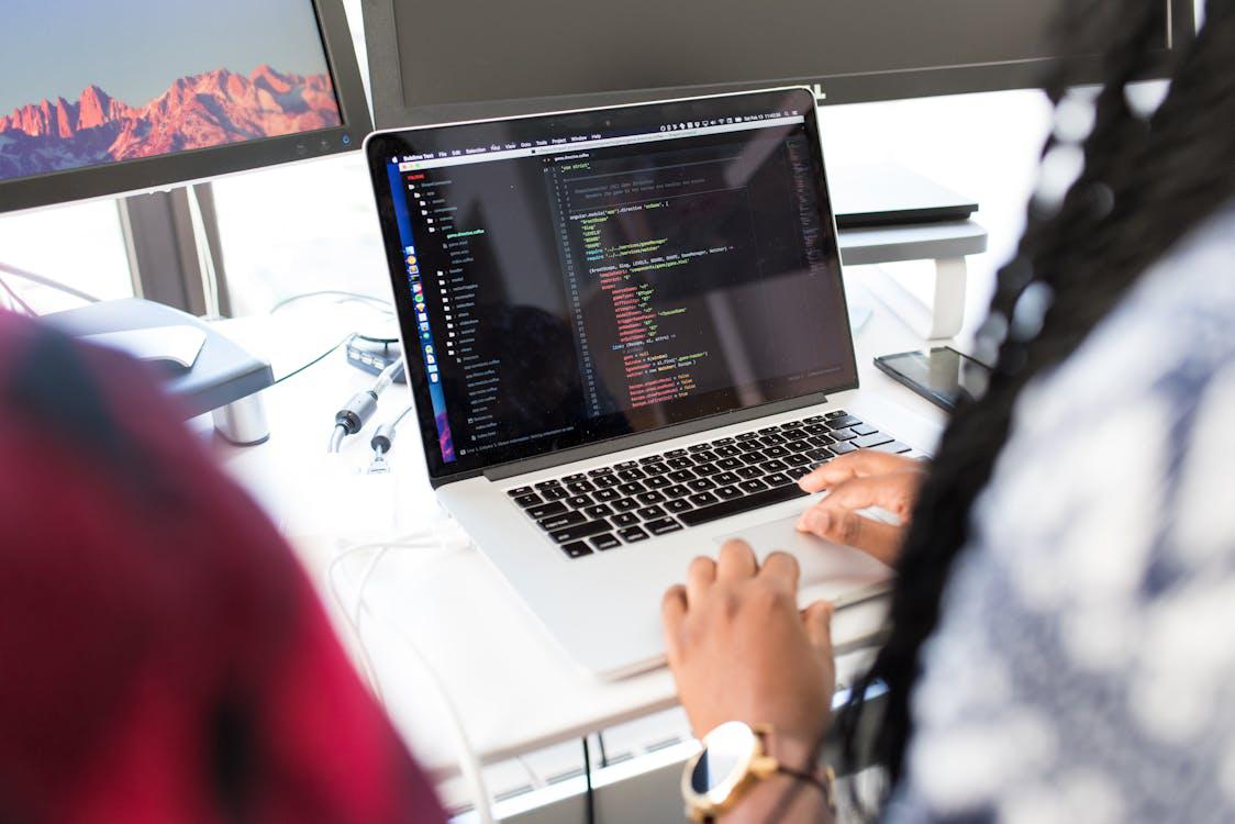 An image of a person coding on a laptop for a web application