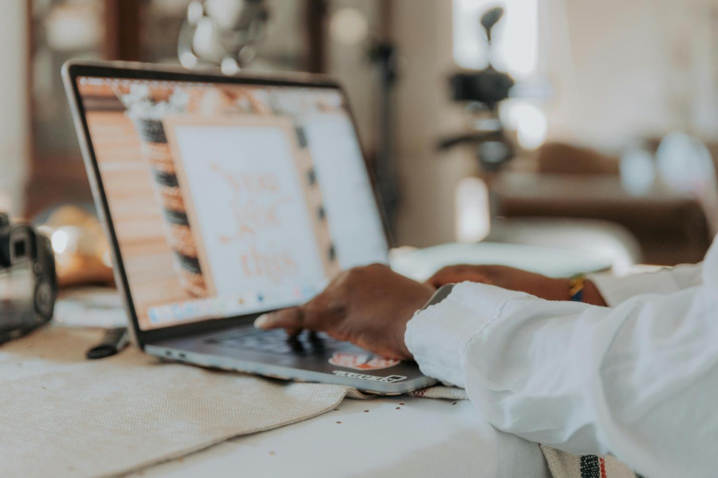 A picture of a person typing on a laptop