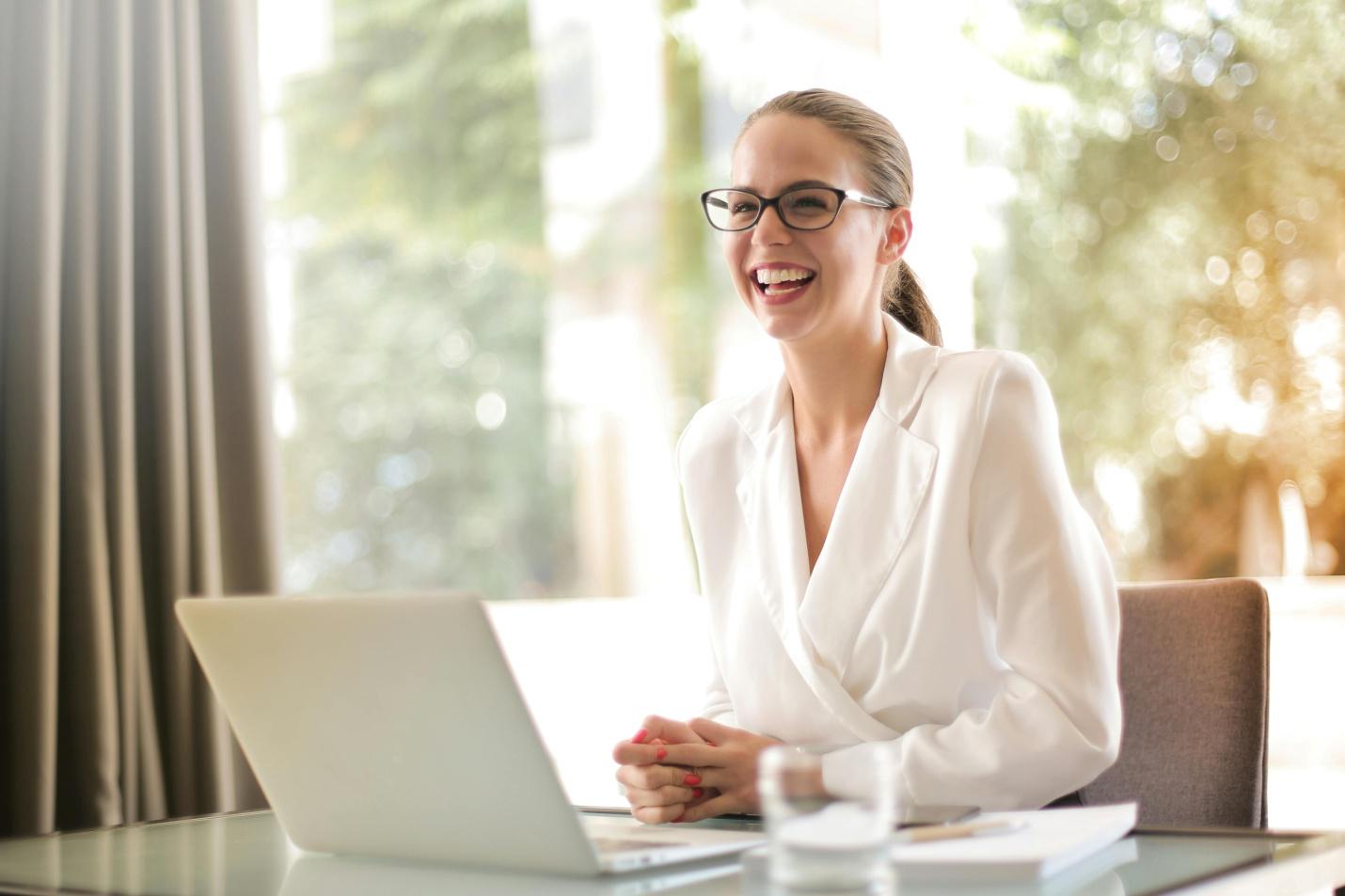 A picture a female employee sitting with a laptop on the table