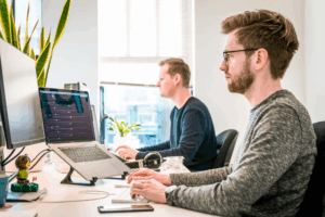 Men working on laptops and desktops